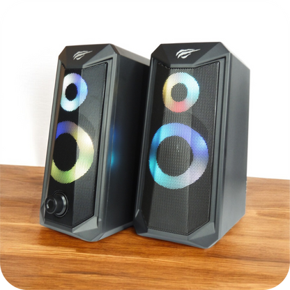 altavoces gamer negros con luces rgb sobre superficie de madera