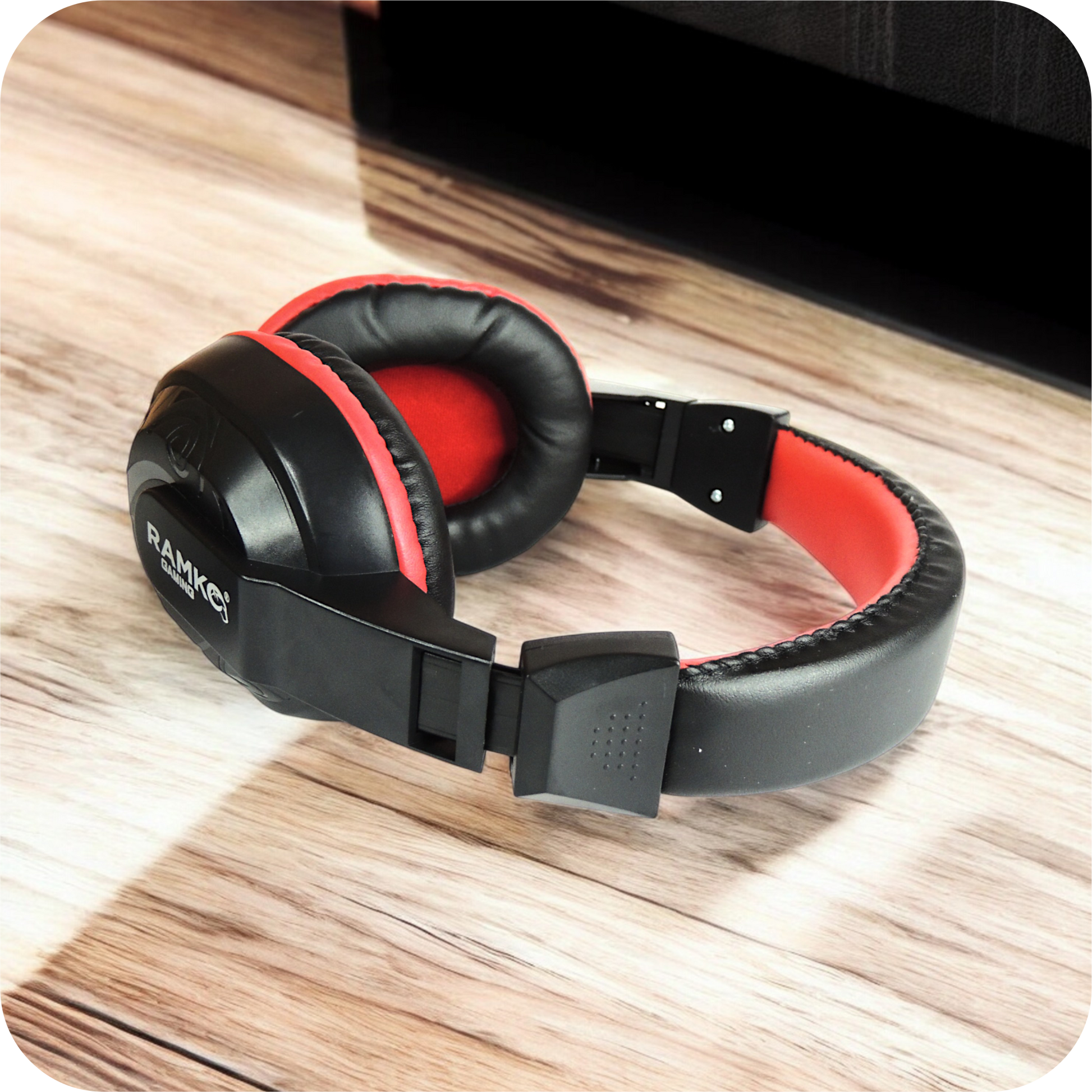 audifonos gaming ramko negros con detalles rojos sobre superficie de madera