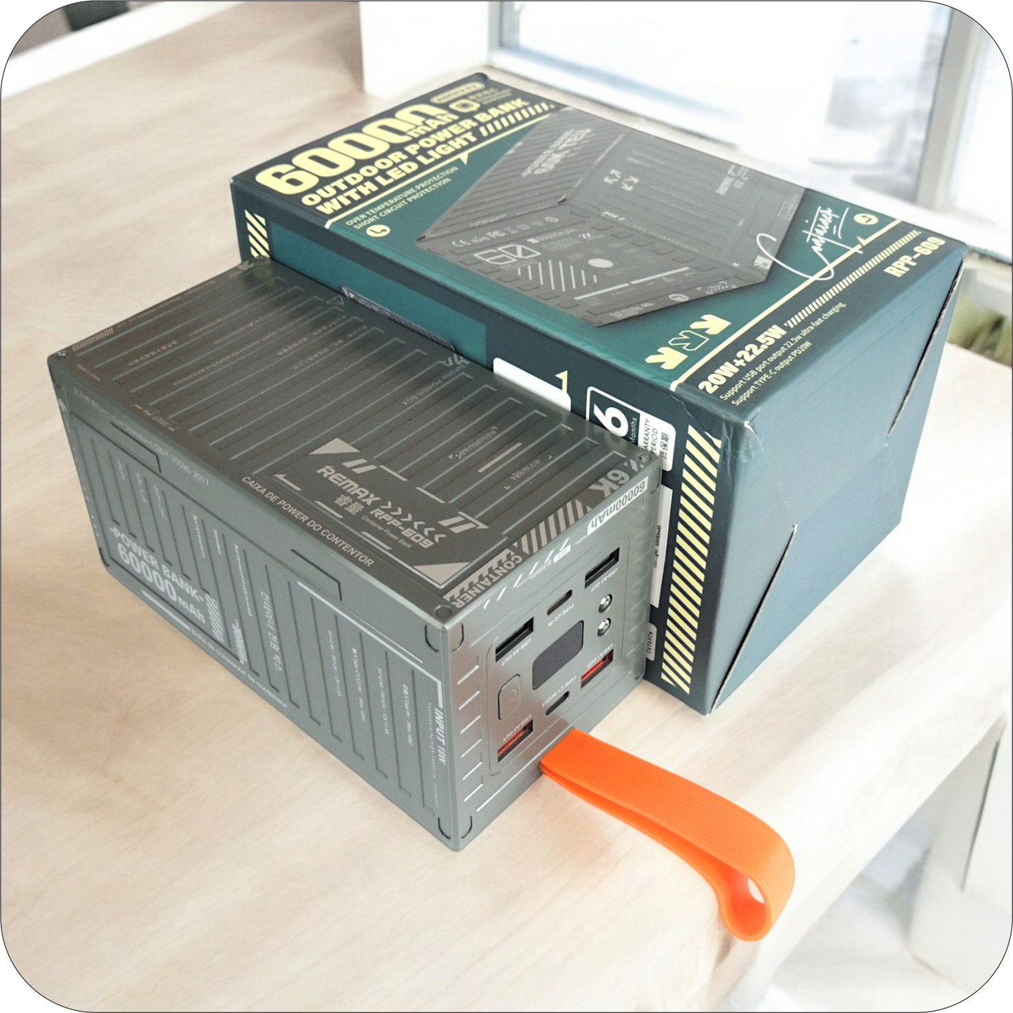 bateria portatil remax de 60000mah junto a su empaque