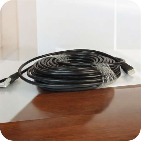 Cable HDMI negro de 20 metros enrollado sobre una mesa de madera
