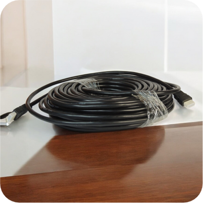 Cable HDMI negro de 20 metros enrollado sobre una mesa de madera
