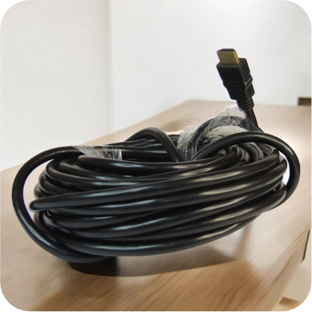 cable de videio HDMI largo, enrollado sobre escritorio de madera