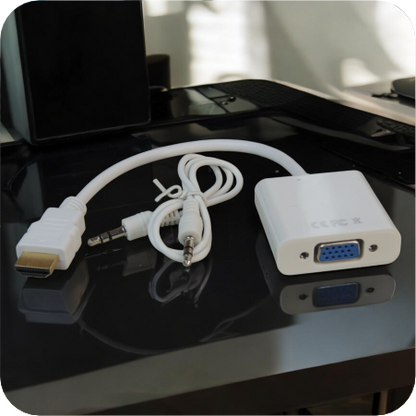 convertidor hdmi a vga y cable de audio blancos en espacio de trabajo