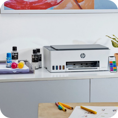 configuración de oficina con impresora HP Smart Tank y suministros de tinta visibles