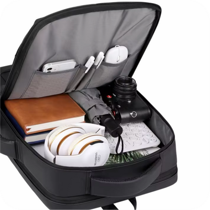 interior de morral negro con celular, lapiceros, mouse, agendas, paragua, camara, audifonos, teclado y laptop