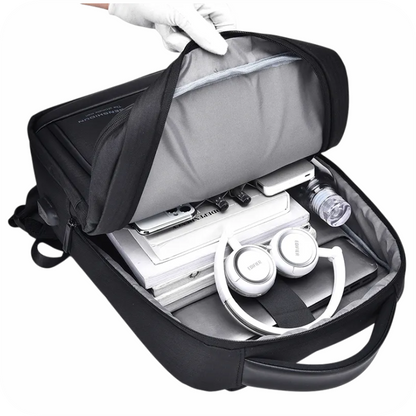 interior de morral negro con celular, lapiceros, botella, libros, laptop y audifonos 