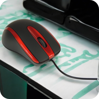 mouse alambrico negro con detalles rojos en uso
