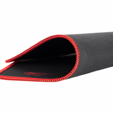 mousepad negro con bordes rojos enrollado sobre superficie blanca 